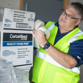 Kamco employee unpacking drywall tape from boxes
