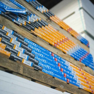 Stacks of drywall products and boxes in warehouse