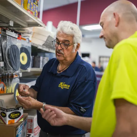 Kamco employee assisting customer in store with products